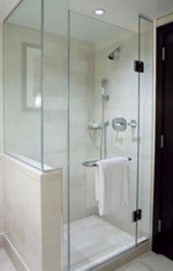 A modern walk-in shower with glass doors.